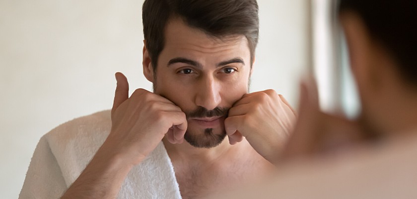 Uomo con la barba che si guarda allo specchio