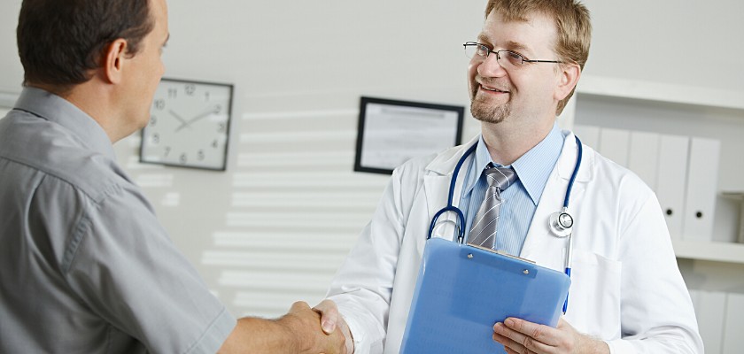 Dottore allegro che stringe la mano al suo paziente